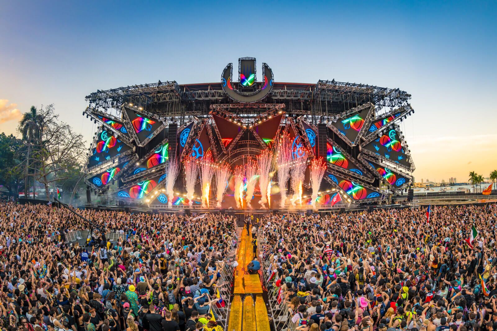 A stage view at Ultra Miami 2024, featuring fireworks and a huge crowd dancing and cheering.