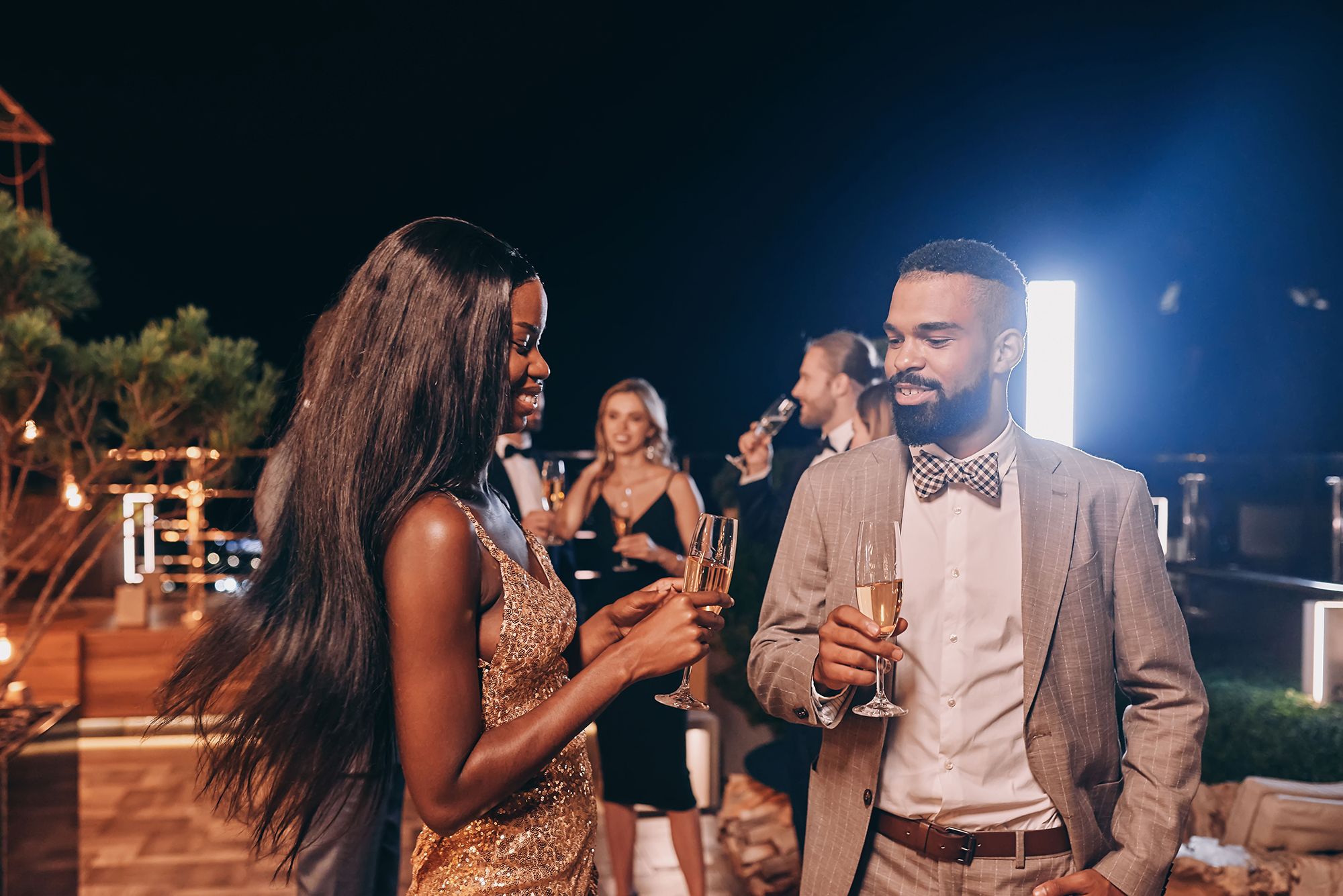 Beautiful young couple dressed up and holding champagne enjoying celebrations for Juneteenth in Miami.